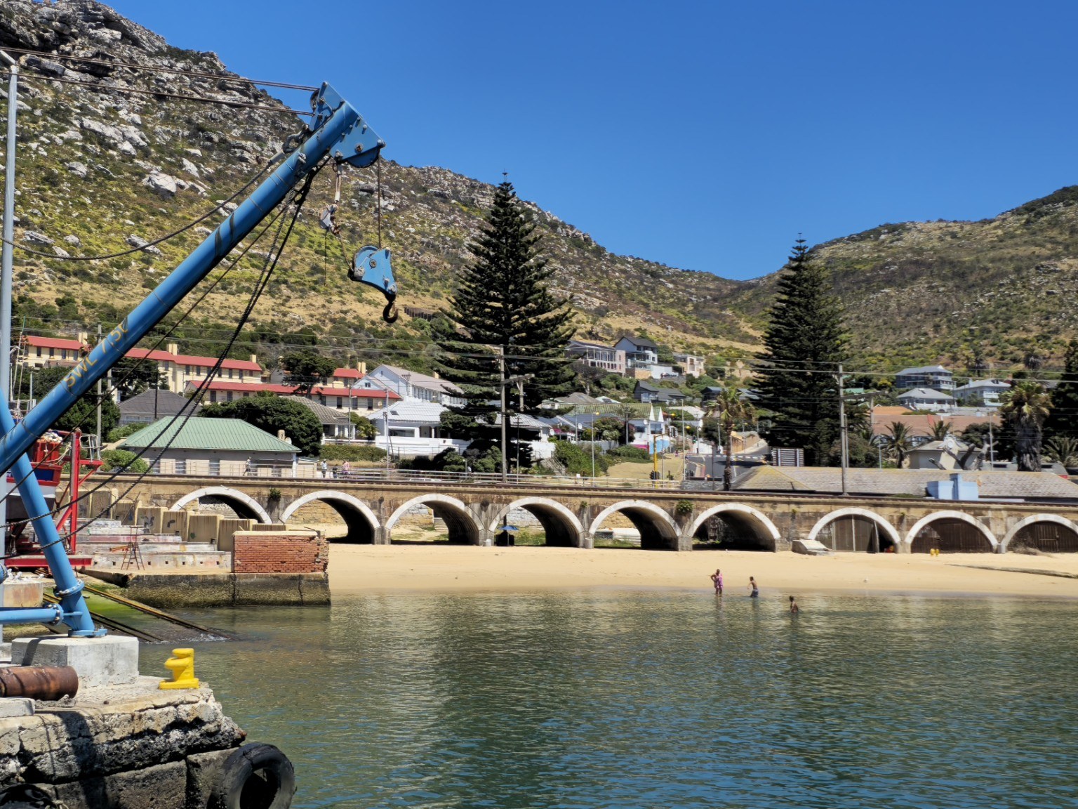 Kalk Bay railway arches & slipway Historic stone railway arches and small sandy cove beside Kalk Bay Harbour with the crane on the slipway, Cape Town