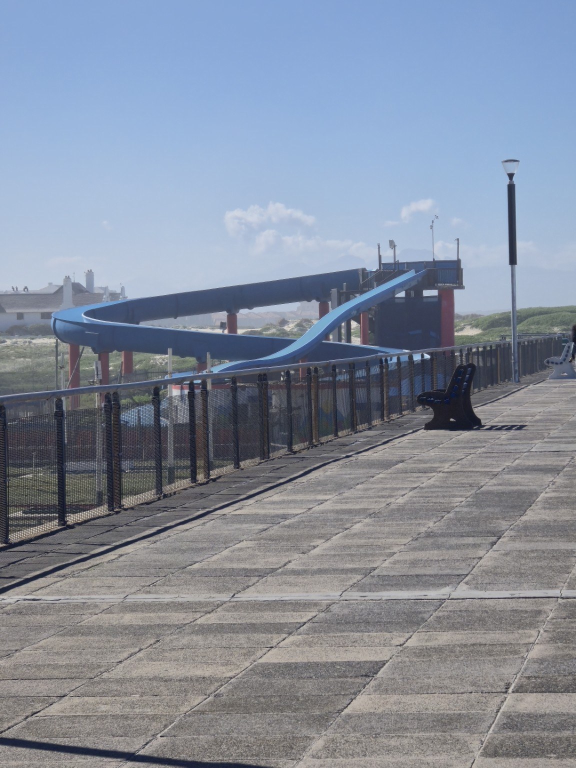 The blue Muizenberg Water Slides towering above the beachfront promenade on Beach Road, Cape Town