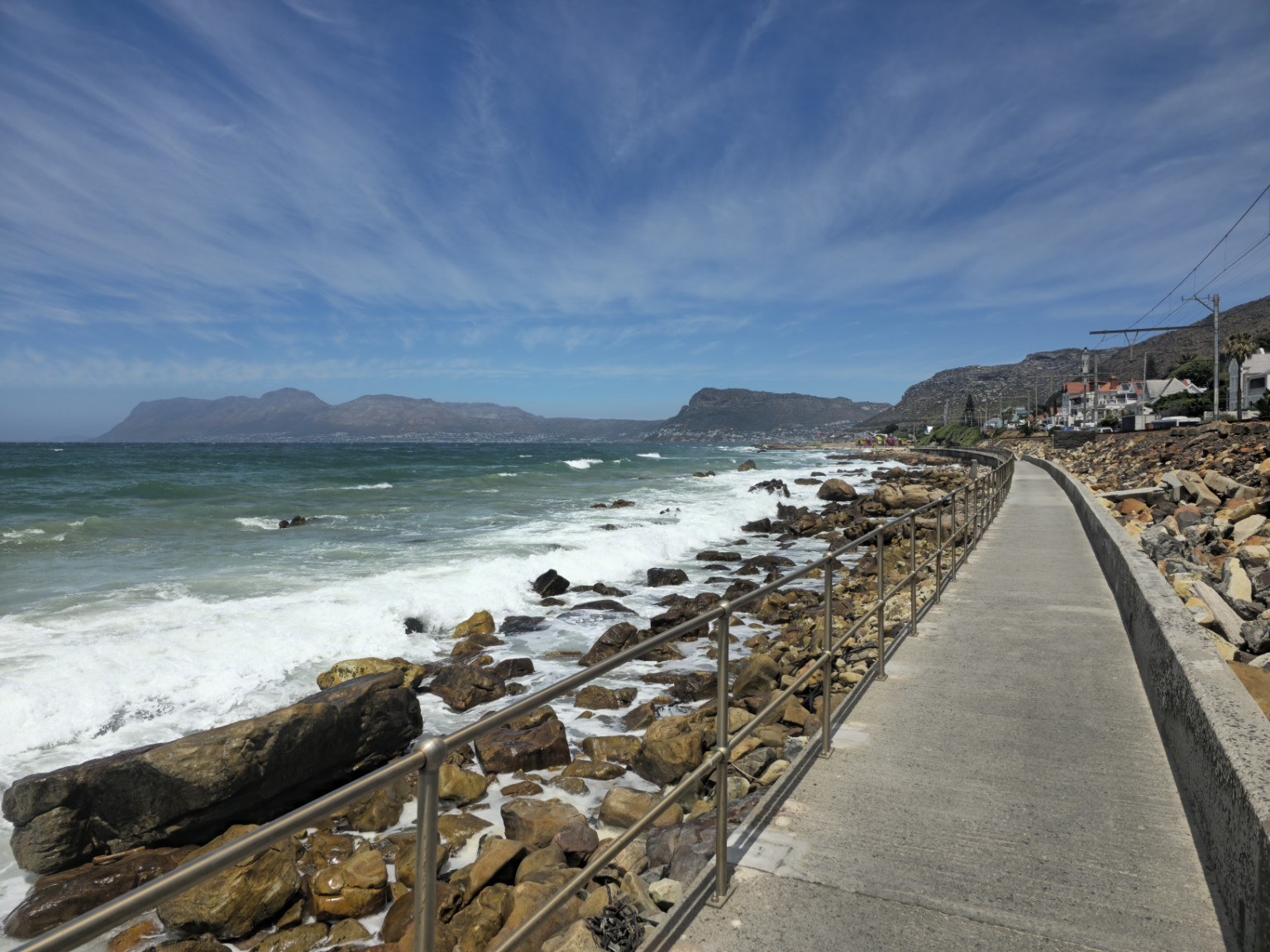Muizenberg scenic promenade The scenic Muizenberg coastal promenade with the rocky False Bay shoreline and mountains in the distance, Cape Town
