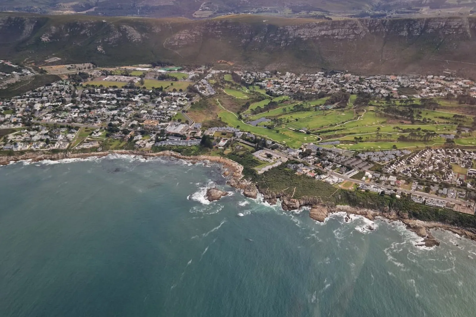 Aerial view of Hermanus, its coastline and the Overberg mountains from a helicopter